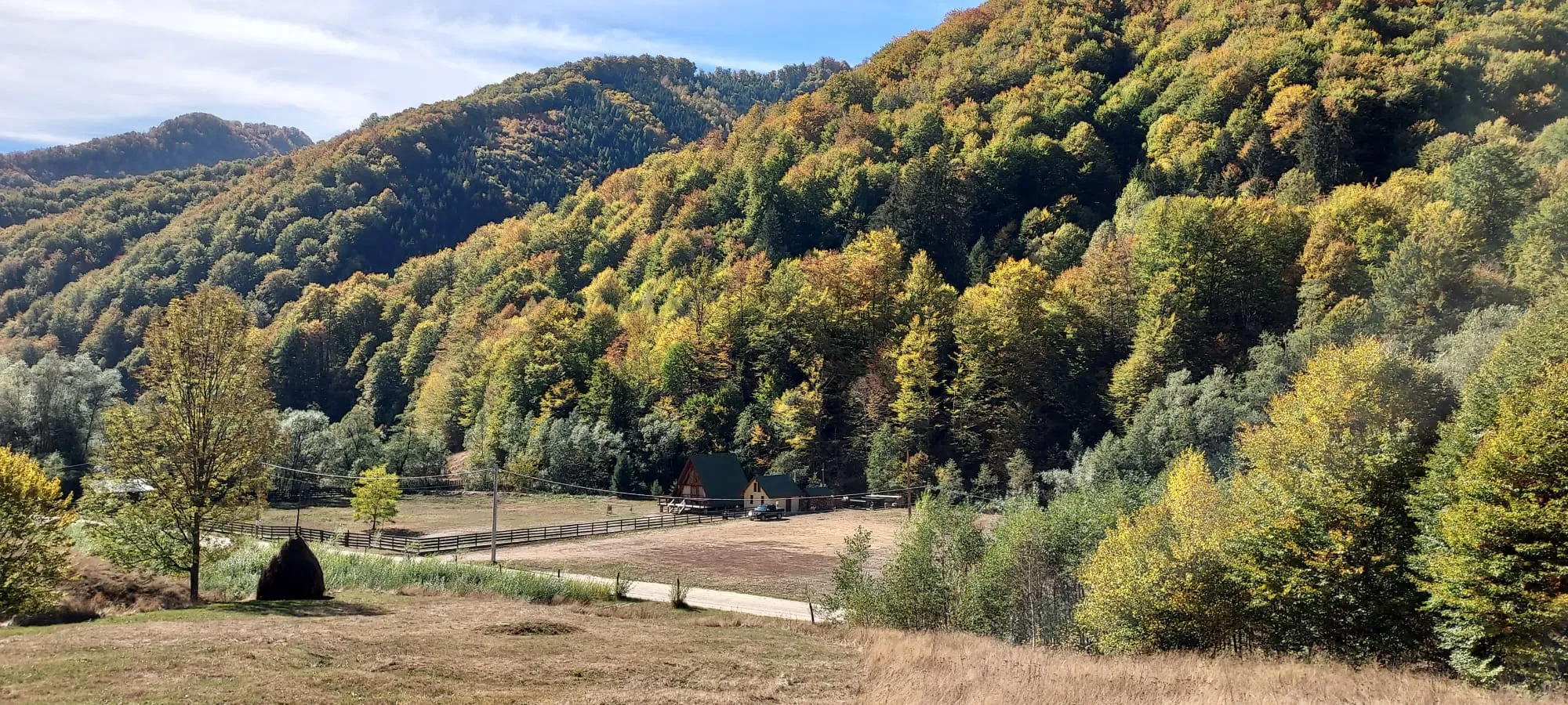 Herbstpanorama des Taia-Tals mit der Hütte am Waldrand